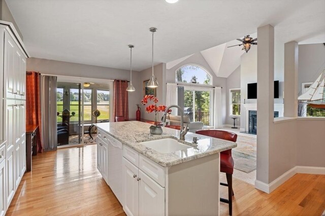 kitchen featuring sink, light hardwood / wood-style floors, a kitchen island with sink, lofted ceiling, and ceiling fan