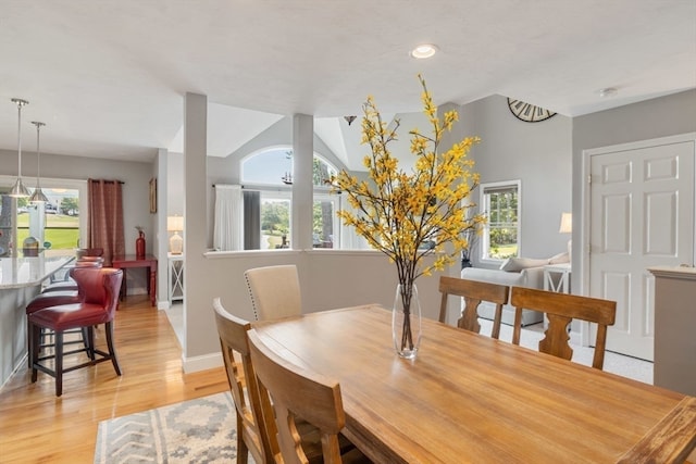 dining space featuring vaulted ceiling and light wood-type flooring