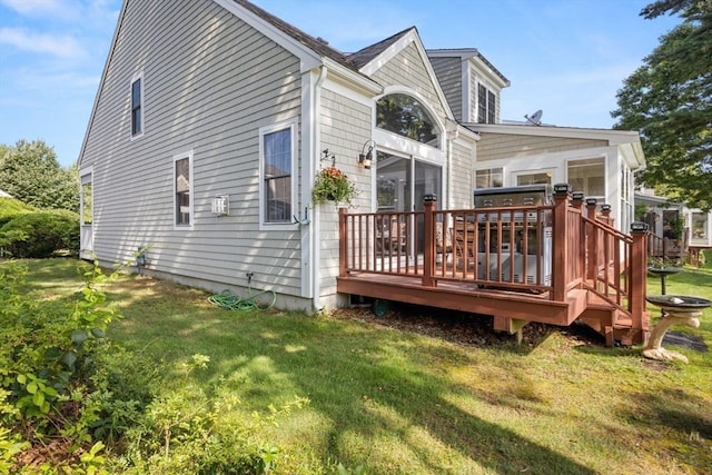 rear view of house with a wooden deck and a lawn