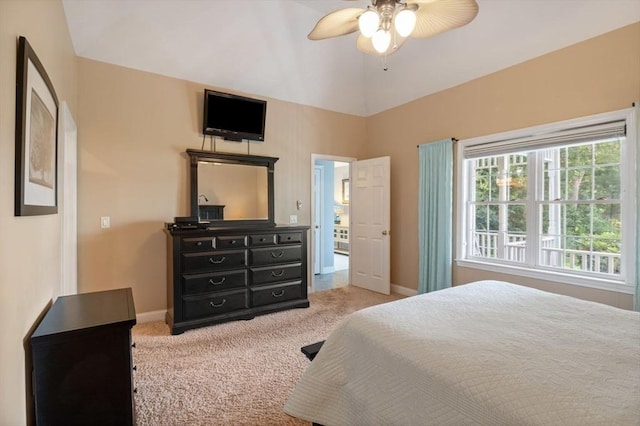 carpeted bedroom with ceiling fan and vaulted ceiling