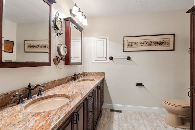 bathroom with double vanity and toilet