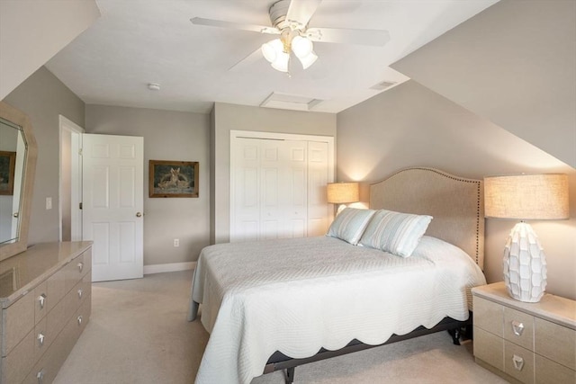 bedroom with ceiling fan, light colored carpet, and a closet