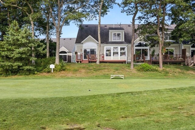 back of house with a deck and a lawn