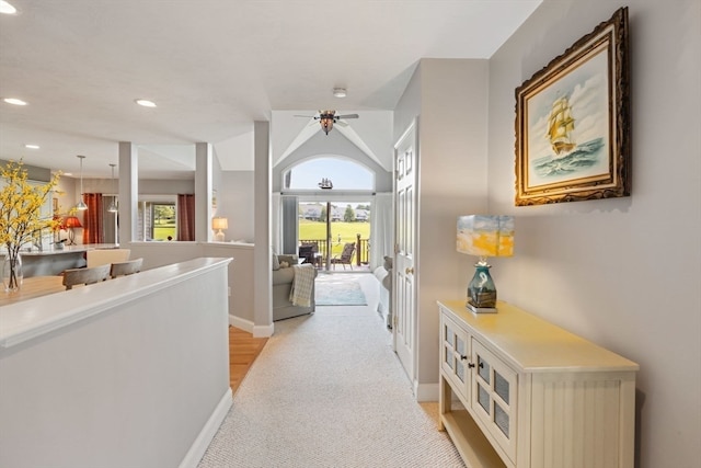 hall featuring light carpet and lofted ceiling