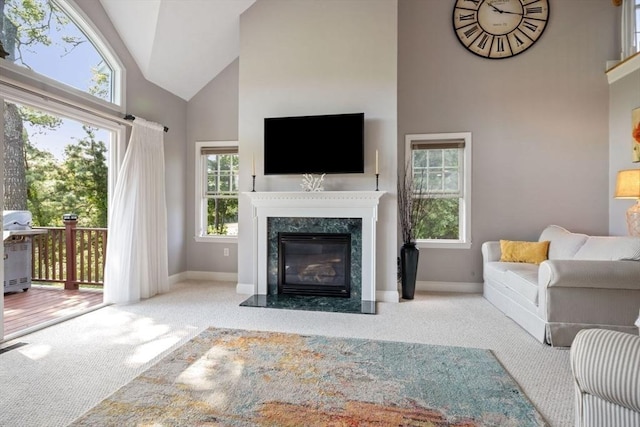 carpeted living room featuring high vaulted ceiling and a premium fireplace