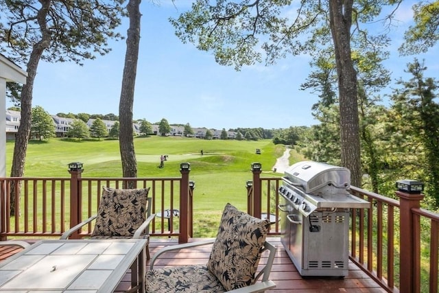 wooden deck with area for grilling and a yard