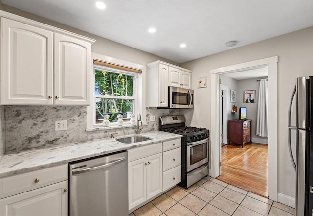 21 Minot St Unit 2A, Boston, MA 02122 - kitchen featuring stainless steel appliances, a sink, white cabinets, light tile patterned floors, and tasteful backsplash