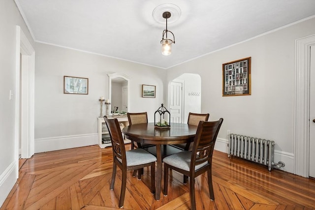 21 Minot St Unit 2A, Boston, MA 02122 - dining area featuring radiator heating unit, arched walkways, crown molding, and baseboards