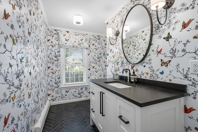 bathroom featuring crown molding, baseboards, wallpapered walls, and vanity