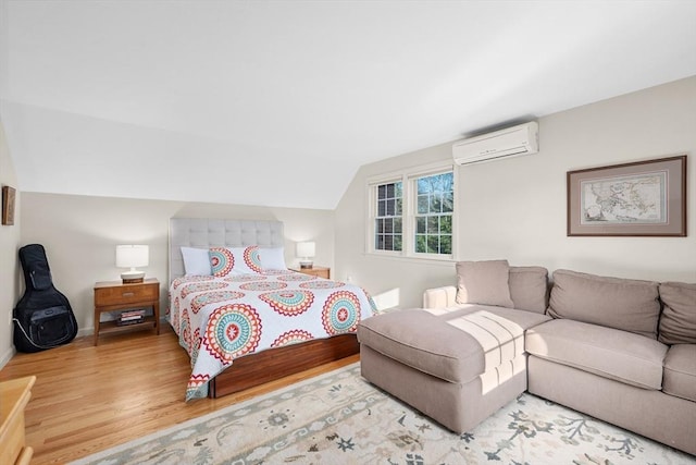 bedroom featuring a wall unit AC, wood finished floors, lofted ceiling, and baseboards
