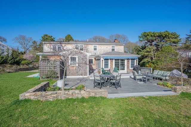 back of property with a patio area, a yard, and a chimney
