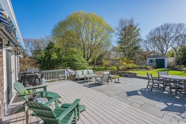 wooden deck with outdoor dining area, a storage shed, an outdoor living space, area for grilling, and an outbuilding