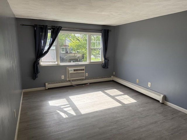 924 Main St Unit 26, Woburn, MA 01801 - empty room with wood finished floors, a wall unit AC, and a baseboard radiator