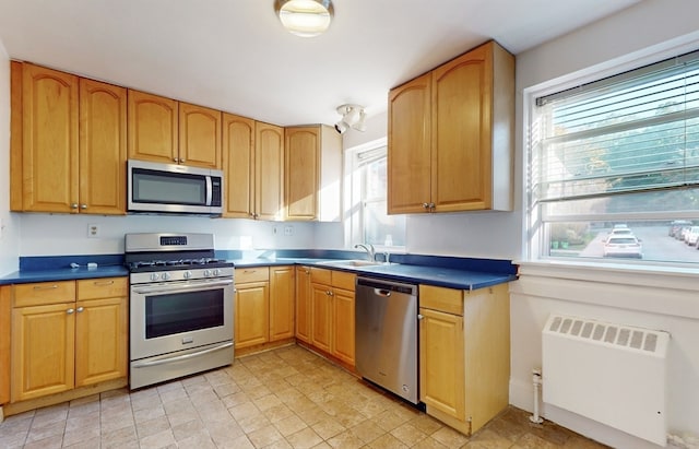 kitchen featuring radiator heating unit, appliances with stainless steel finishes, and sink