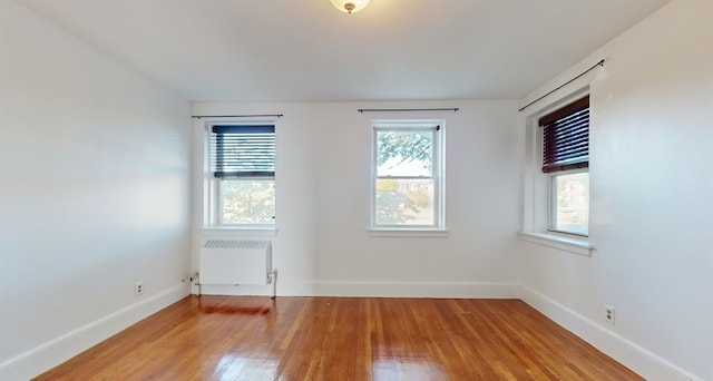 spare room featuring hardwood / wood-style floors and radiator