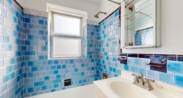 bathroom featuring tiled shower / bath, sink, and tile walls