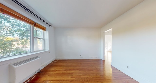 unfurnished room with radiator and hardwood / wood-style flooring