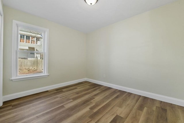 empty room featuring baseboards and wood finished floors