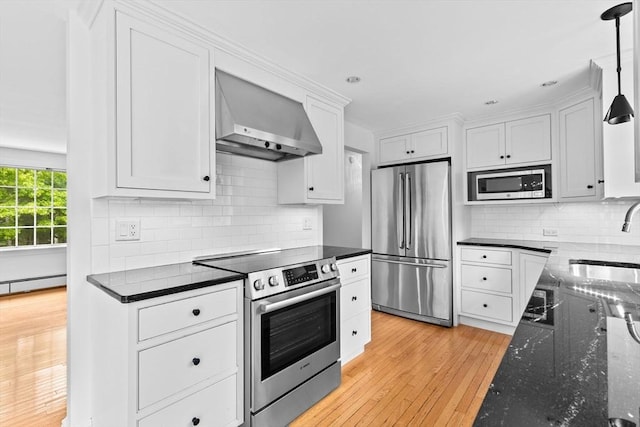 258 Plympton Rd, Plymouth, MA 02360 - kitchen featuring stainless steel appliances, wall chimney range hood, a sink, white cabinetry, and light wood-type flooring