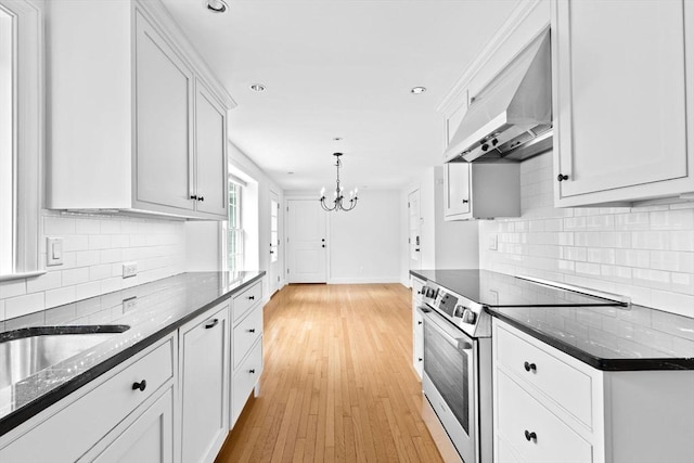 258 Plympton Rd, Plymouth, MA 02360 - kitchen featuring stainless steel range with electric cooktop, wall chimney range hood, a chandelier, white cabinets, and recessed lighting