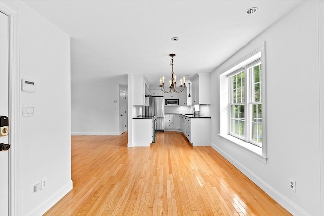 258 Plympton Rd, Plymouth, MA 02360 - kitchen featuring appliances with stainless steel finishes, a sink, a chandelier, dark countertops, and baseboards