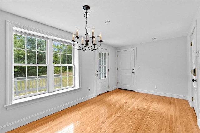 258 Plympton Rd, Plymouth, MA 02360 - unfurnished dining area with a chandelier, plenty of natural light, light wood-style floors, and baseboards
