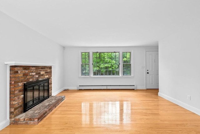258 Plympton Rd, Plymouth, MA 02360 - unfurnished living room with a baseboard heating unit, a brick fireplace, wood finished floors, and baseboards