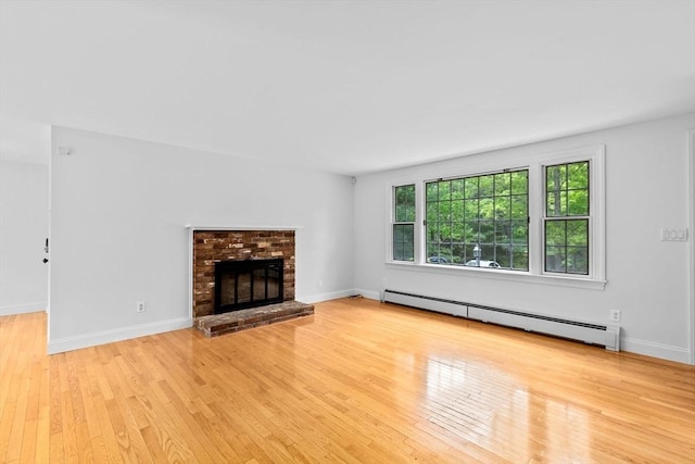 258 Plympton Rd, Plymouth, MA 02360 - unfurnished living room featuring baseboard heating, wood finished floors, a fireplace, and baseboards