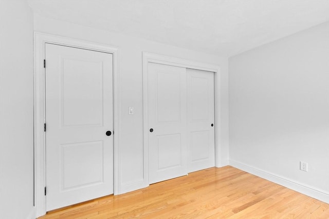 258 Plympton Rd, Plymouth, MA 02360 - unfurnished bedroom featuring a closet, light wood-style floors, and baseboards