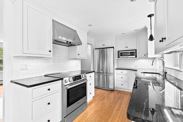 258 Plympton Rd, Plymouth, MA 02360 - kitchen featuring stainless steel appliances, wall chimney exhaust hood, light wood-style flooring, and tasteful backsplash