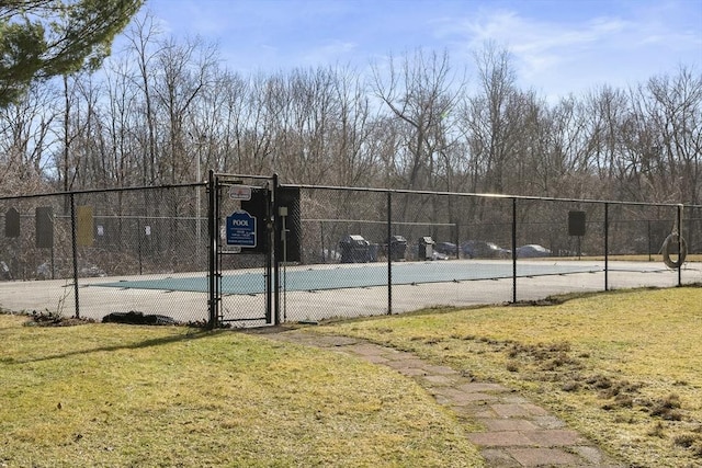 view of tennis court featuring a gate, community basketball court, and fence