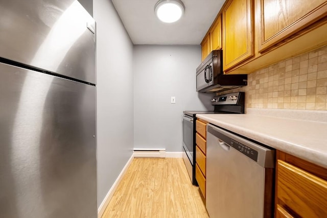 27 Mason Ct Unit 27, Amesbury, MA 01913 - kitchen with appliances with stainless steel finishes, baseboard heating, decorative backsplash, brown cabinets, and light wood-style flooring