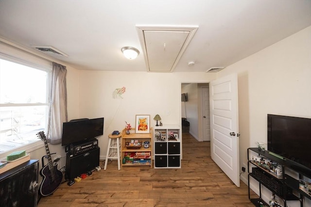 game room featuring attic access, wood finished floors, and visible vents