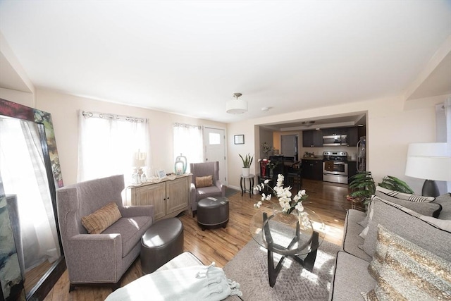 living area with light wood-type flooring and baseboards