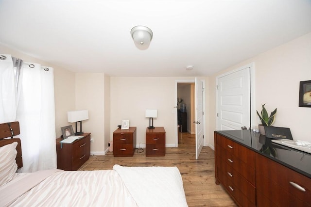 bedroom with baseboards and light wood-style flooring