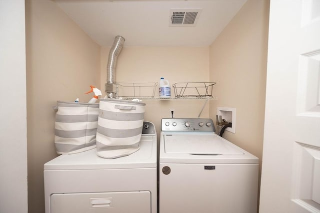 washroom with washing machine and clothes dryer, laundry area, and visible vents