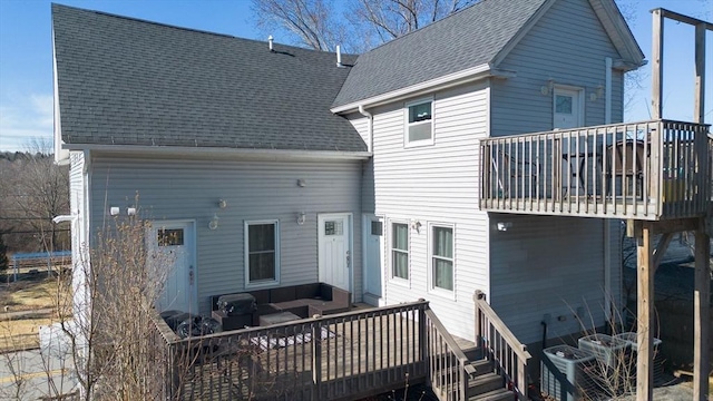 back of property featuring a deck and roof with shingles