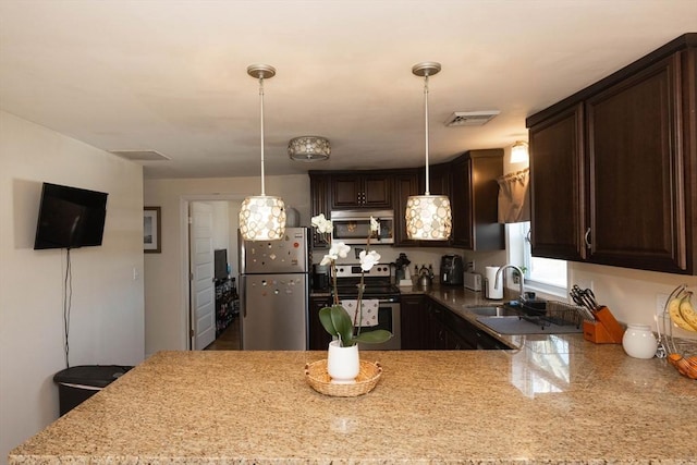 kitchen featuring dark brown cabinetry, a peninsula, visible vents, and appliances with stainless steel finishes