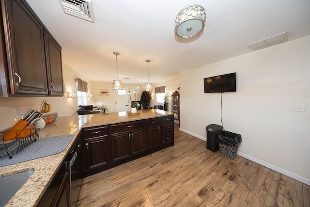 kitchen featuring light wood-type flooring, visible vents, a peninsula, and dark brown cabinets