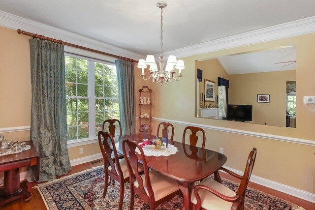 dining space featuring lofted ceiling, ornamental molding, and hardwood / wood-style floors