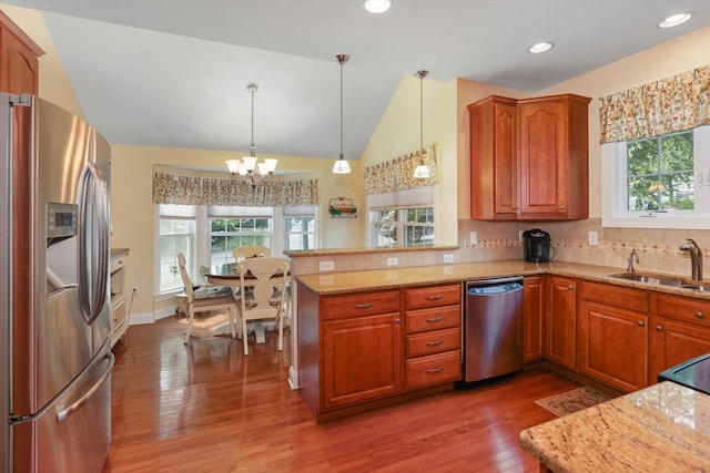 kitchen with pendant lighting, an inviting chandelier, stainless steel appliances, and a wealth of natural light