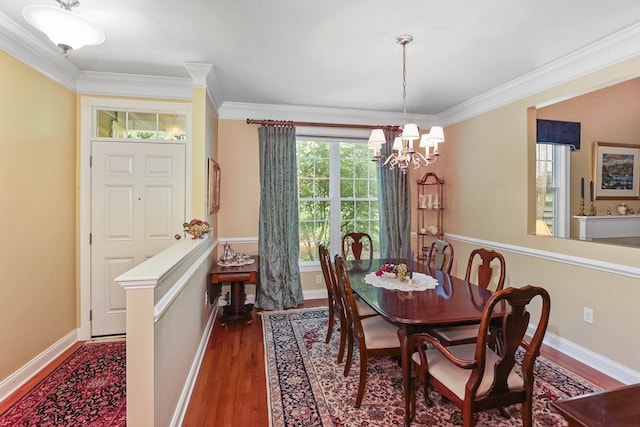 dining area with dark hardwood / wood-style floors, a chandelier, and crown molding