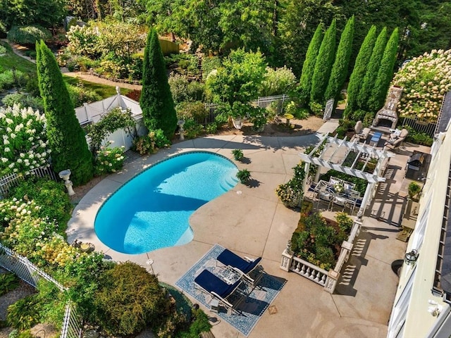 view of pool with a fenced backyard, a patio, and exterior fireplace