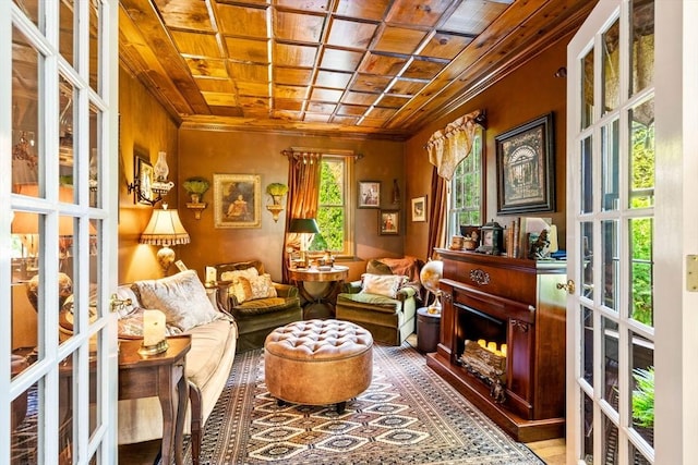 living area with ornamental molding, wooden ceiling, and french doors