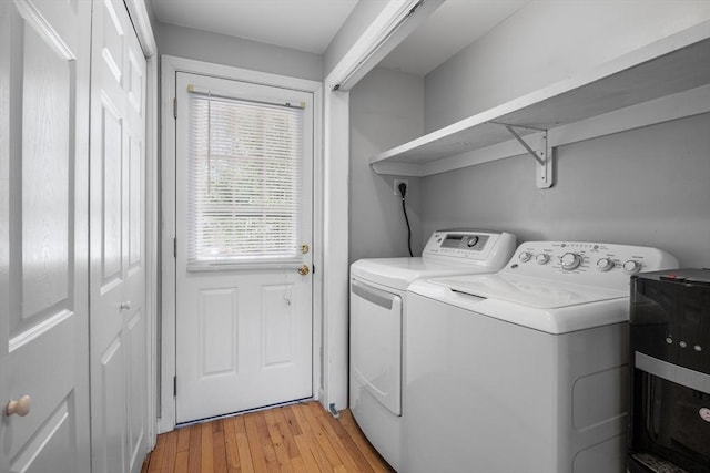 laundry area featuring laundry area, light wood finished floors, and washer and clothes dryer