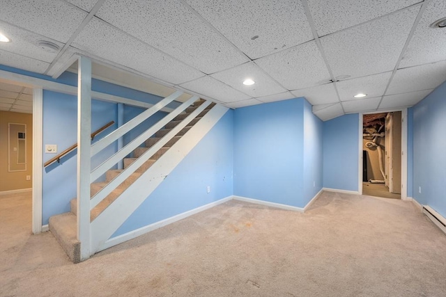 finished basement with stairway, recessed lighting, a paneled ceiling, and baseboards