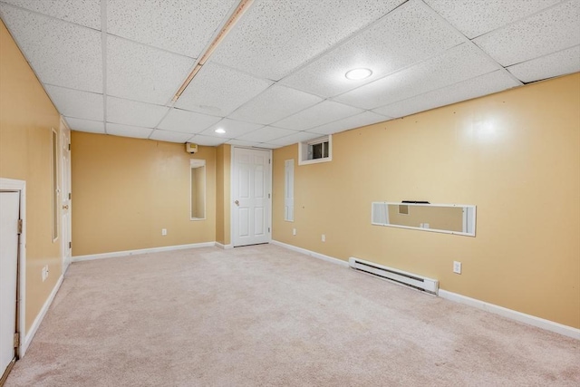 finished below grade area with a drop ceiling, carpet, baseboards, and a baseboard radiator