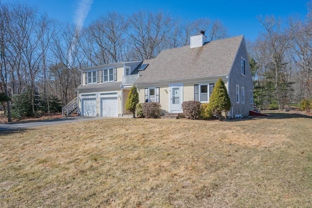 view of front of home with driveway, a front lawn, an attached garage, a shingled roof, and a chimney