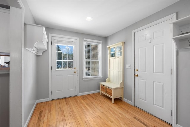 doorway featuring baseboards and light wood-type flooring