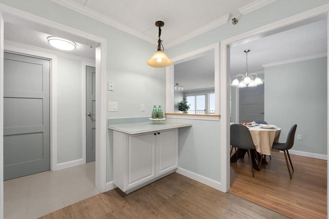 kitchen with baseboards, light countertops, and decorative light fixtures